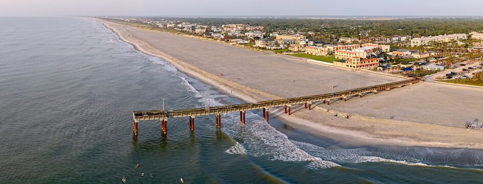 Aerial view of the weathered Saint Johns County pier stretching over the sandy beach meeting the vast ocean, Saint Augustine Beach, Florida, United States.