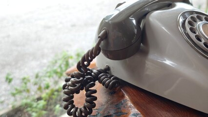 Old grey phone with dial plate, vintage telephone.