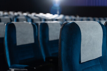 Blue chairs in an empty movie theater, low light