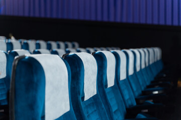 Blue chairs in an empty movie theater, low light