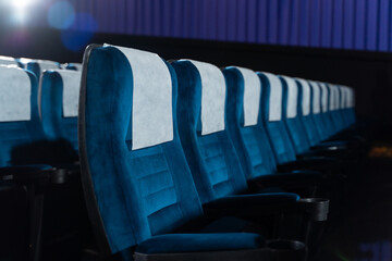 Blue chairs in an empty movie theater, low light