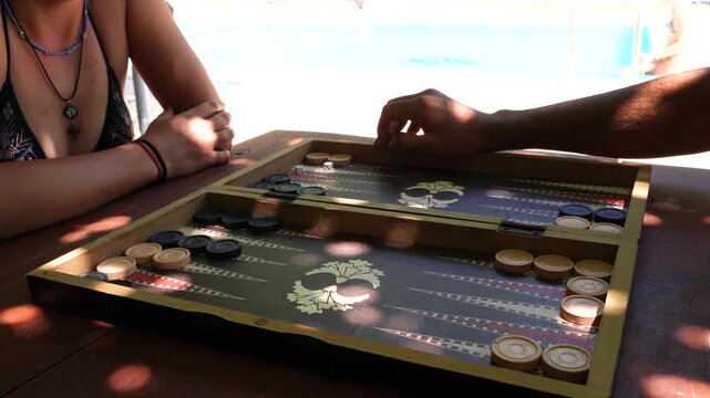 Close-up on a Backgammon Game with People Relaxing by the Swimming Pool