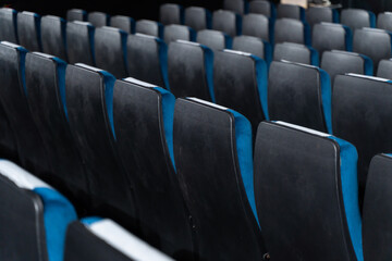 Blue chairs in an empty movie theater, low light