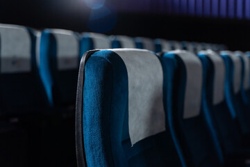 Blue chairs in an empty movie theater, low light