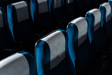 Blue chairs in an empty movie theater, low light