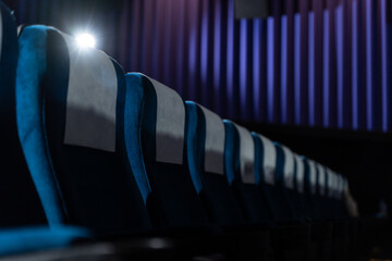 Blue chairs in an empty movie theater, low light
