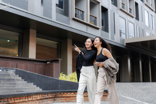 Two young businesswomen walking and talking in the city center