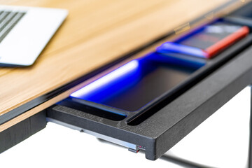 Opened drawer with light inside. Modern office table with open drawer