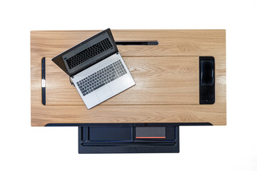 Office wooden dark brown desk table with computer, supplies and open drawer. Top view with copy space isolated on white