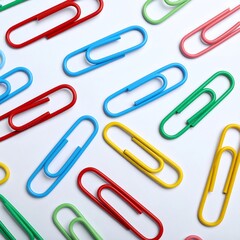 Colorful paper clips arranged on white background