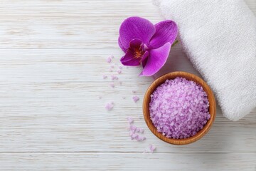 Cosmetic and beauty concept for Banner Spa featuring pink sea salt a white towel and a purple orchid on a white wooden surface Flatlay design
