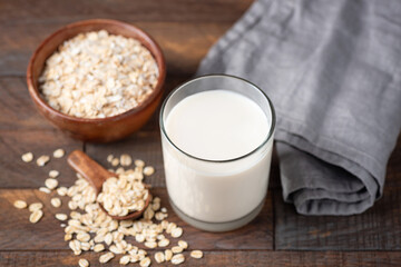 Non dairy lactose free alternative milk Oat Milk in a glass on wooden table background