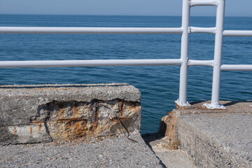 old concrete wall and metal railing by the sea.