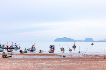 Local coastal fishing boats are anchored on the sandy beach of a fishing village.