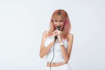 Happy young Asian woman singing with pink hair