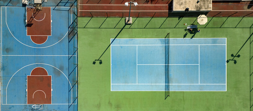 Aerial view of geometric harmony as tennis and basketball courts meet, contrasting the green of the field with the blue courts, Stobre&Auml;, Split-Dalmatia County, Croatia.