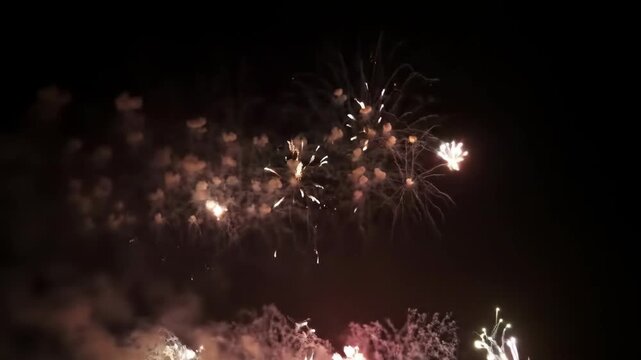 Night fireworks display with bright sparks and colorful explosions. Festive fireworks illuminate dark night sky creating magical atmosphere.