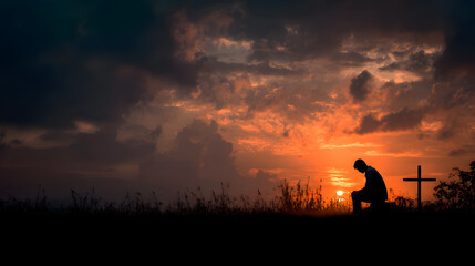 Fototapeta premium Man praying at cross silhouette at sunset seeking god faith and christianity hope and religion concept
