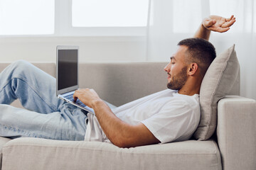 Relaxed man engaging in a digital detox while connecting with technology at home, embracing...