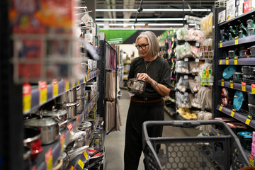 Woman exploring kitchenware and home goods in a modern retail store environment