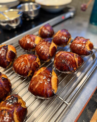 Golden brioche buns cooling on wire rack.
