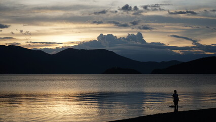 Fototapeta premium people standing in the lake while sunset