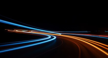 Abstract light trails of cars streak through the city at night with a long exposure