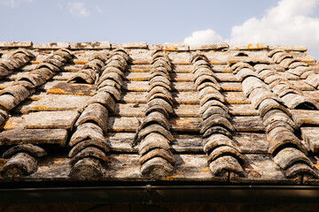 Old terracotta roof tiles covering a building in tuscany, italy, on a sunny day