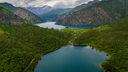Fototapeta premium aerial view of sary chelek lake in Kyrgyzstan drone fly above scenic landscape with mountains in natural reserve
