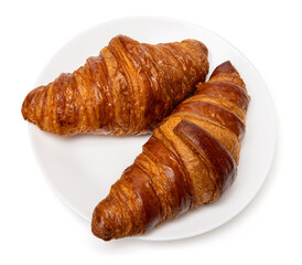 Two freshly baked classic delicious fresh organic croissants on white ceramic plate isolated on white background
