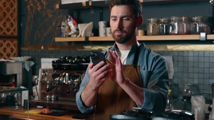 Satisfied happy Caucasian barista man showing green screen mobile phone thumb up in cafeteria cafe male small business entrepreneur recommend application advertisement guy waiter approval catering app