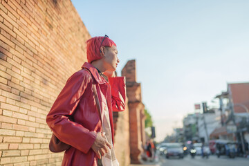 Gen z girl leather fashion with punk Asian woman tourist of local city Southeast Asia travel trendy pink hairstyle young female punk traveler walking around in town