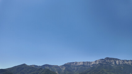 panorama Rocky mountain range under clear blue summer sky.