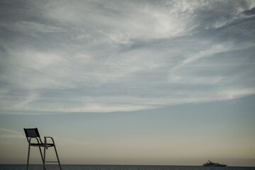 Empty Lifeguard Chair by the Ocean at Sunset
