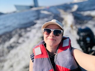young woman enjoys riding on motor boat on Neva river, Saint Petersburg