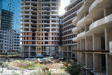 A bustling construction site with a large crane and modern buildings under construction, with...