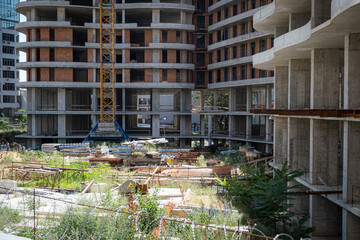 A bustling construction site with a large crane and modern buildings under construction, with...