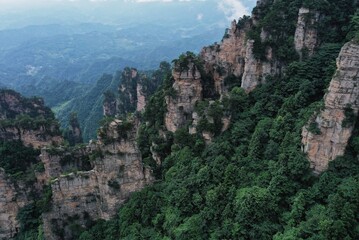 Morning mist envelops the majestic Zhangjiajie mountains in a serene natural landscape
