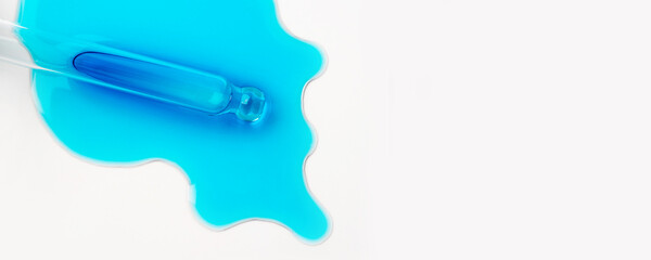Drops of cosmetics and a pipette on a white background. A product for skin, face or hair care.