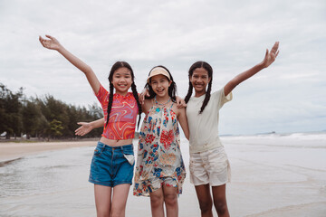 Friends enjoying the beach together Asian and multicultural kids smiling and playing by the sea, expressing childhood joy, freedom.