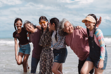 Happy Asian family group, senior women and kids enjoying playful beach. Celebrating love, wellness, and multi generational togetherness by the sea.