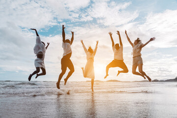 Diverse group of joyful friends jumping together on the beach with energy and excitement. freedom, active lifestyle, celebration.