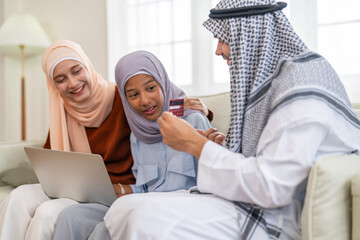 Obraz premium Muslim family using tablet for online shopping and holding credit card, islamic digital lifestyle and modern islamic banking, e-commerce trends, halal marketplace and islamic finance family planning