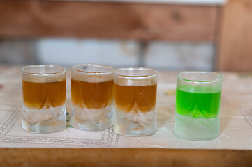 A selection of Colorful Shot Glasses beautifully displayed on a Wooden Table, ready for use