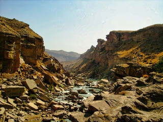A rocky canyon with a river running through it