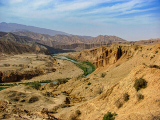 A desert landscape with a river running through it