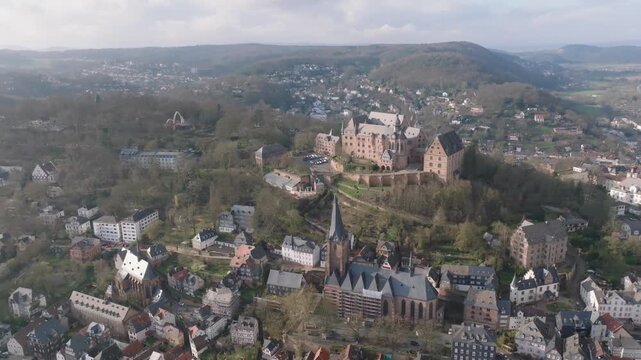 Drone orbit CW shot from Perched atop the 287 m Schlossberg hill, overlooking Marburg&rsquo;s Altstadt in Hesse, Germany