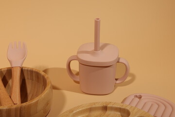 Pastel Pink Silicone Baby Cup, Bamboo Utensils, and Tray Set: Minimalist, Modern, Neutral Background.
