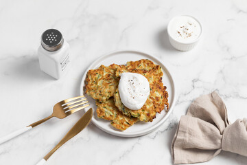 vegetarian zucchini fritters, light marble background