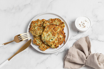 vegetarian zucchini fritters, light marble background